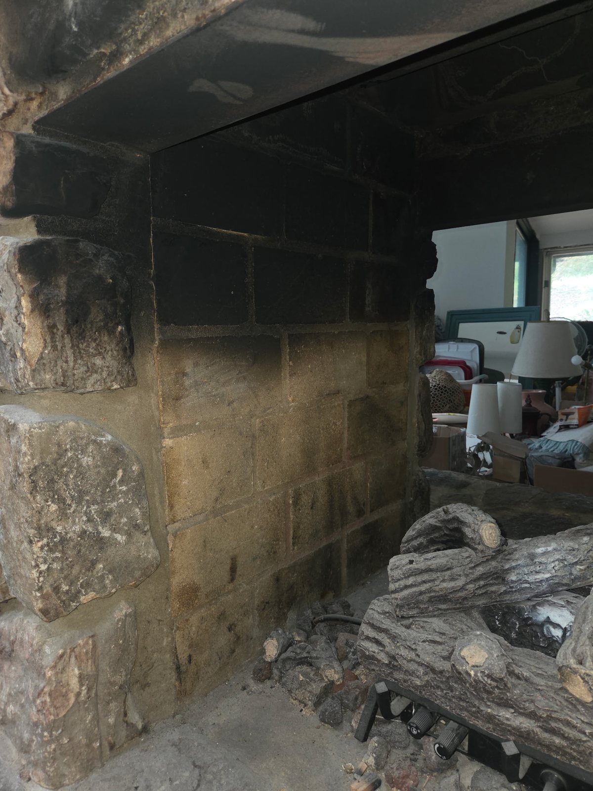 Fireplace firebrick and stone darkened by heavy soot before laser cleaning